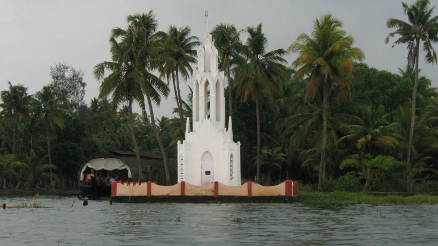 a church and some palm trees in a body of water
