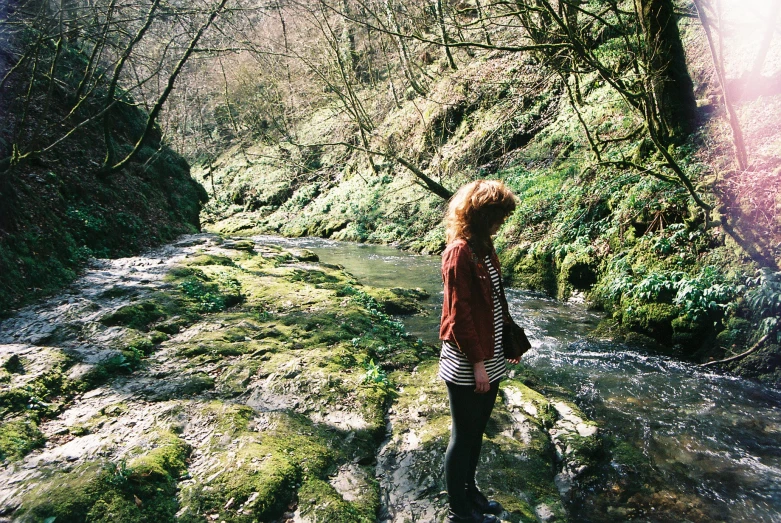 a person standing on a hill near water