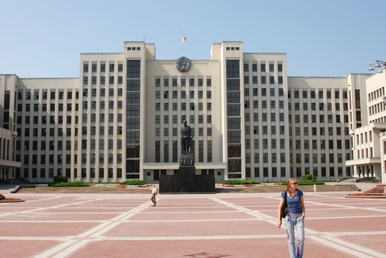 two woman stand in front of a large building with a clock on it's tower