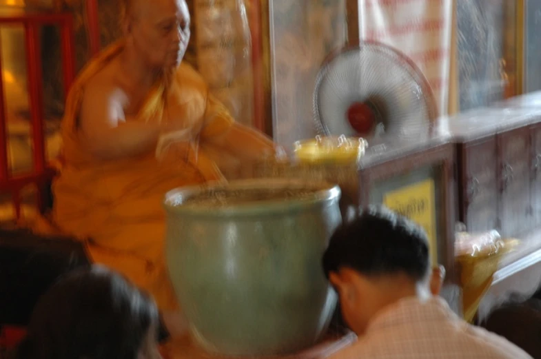 a man pouring soing into a vase that is being filled