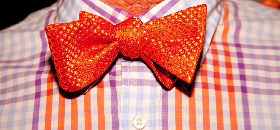 the orange bow tie is very elaborate on the collar