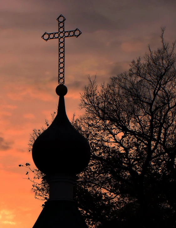 a cross on a steeple in the sky