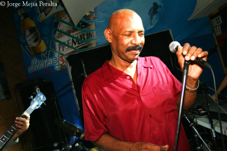 a man in a red shirt and a microphone