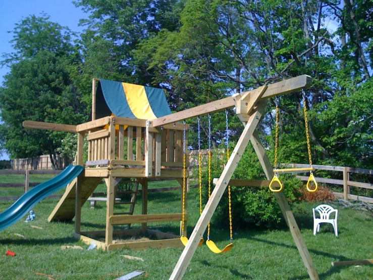 a wood swing set with slides and swings for children