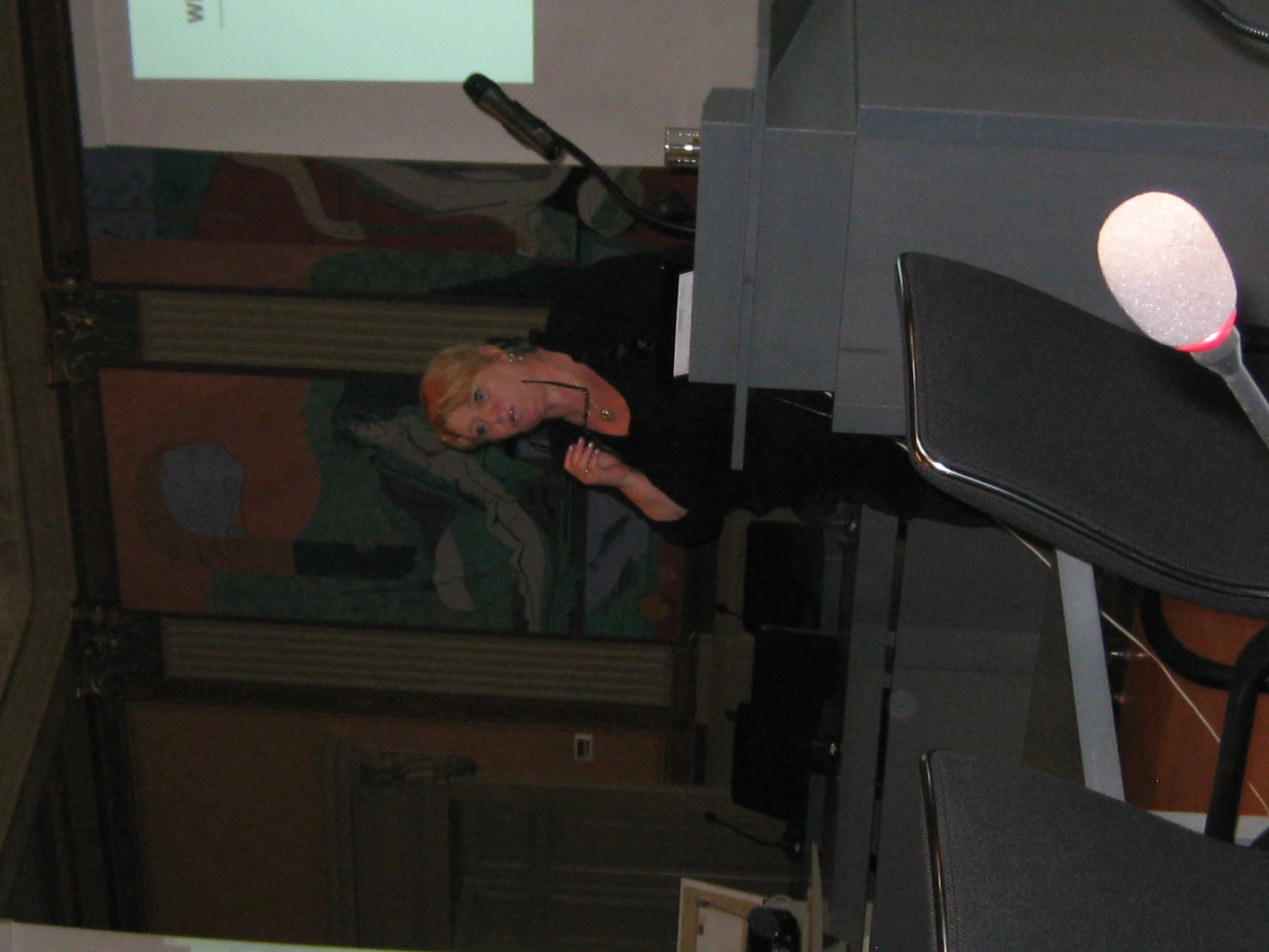 a woman in a black shirt is standing at a podium