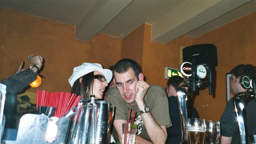 a man and woman standing next to each other near a bar