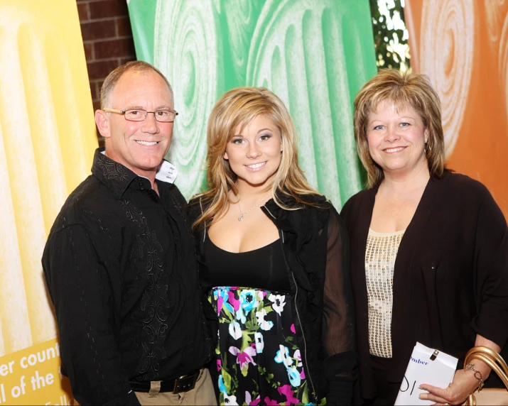 two men and one women are posing for the camera