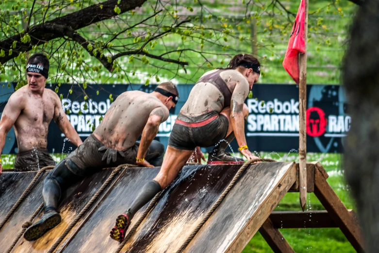 the men are standing on top of a wooden structure