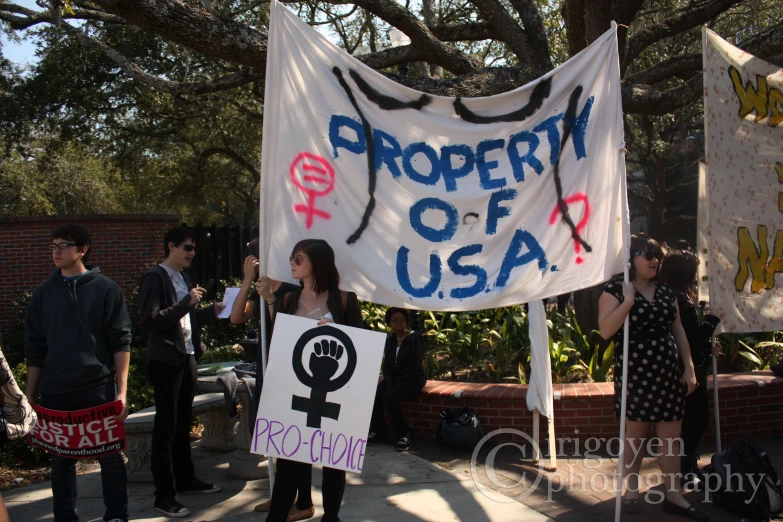 protesters hold signs in support of women's rights at a demonstration