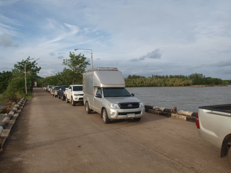 there are many white vans parked by the water