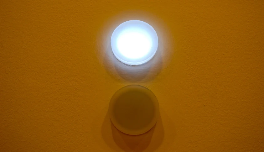 a round light sitting on the wall next to the window
