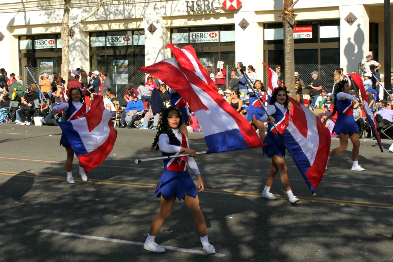 a parade in the city that features girls marching through the streets