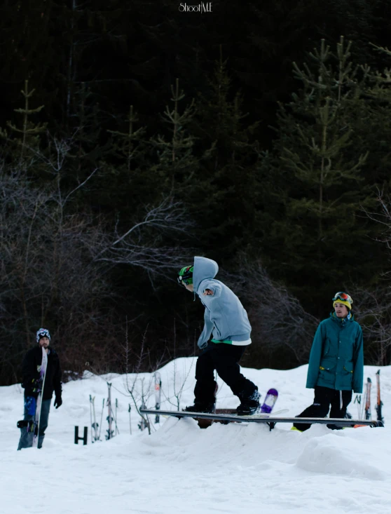 two people are doing a trick on the snowboard