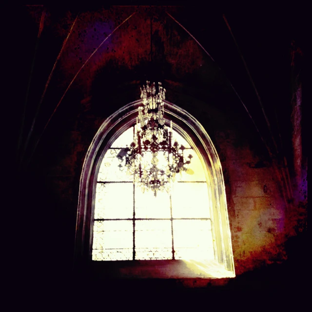 sunlight coming through an arched window into a chandelier