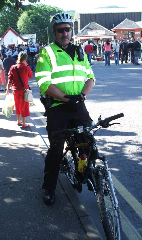 a man standing next to his bike wearing safety clothing