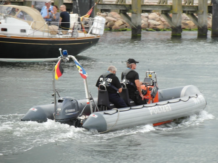 three men in an aluminum raft floating next to each other