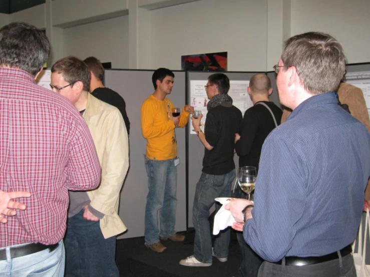 a group of people standing around each other and drinking wine