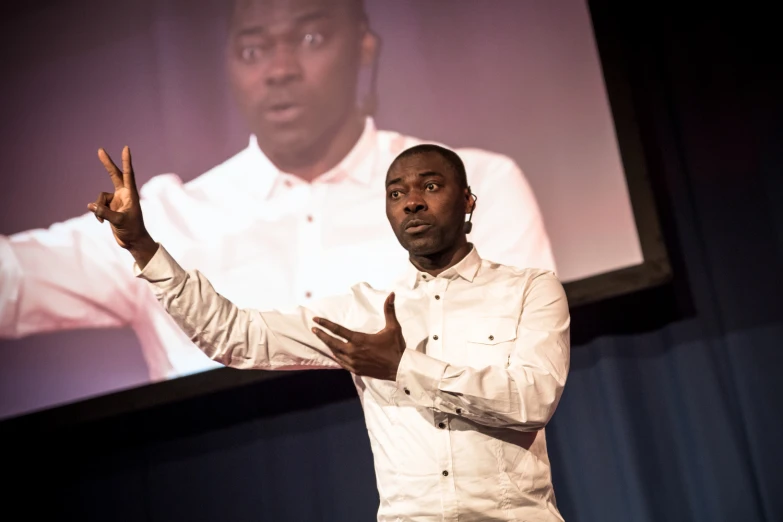 a man in white shirt and tie giving a presentation