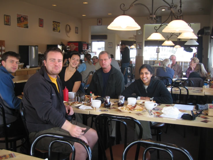 people sitting around a table with plates of food