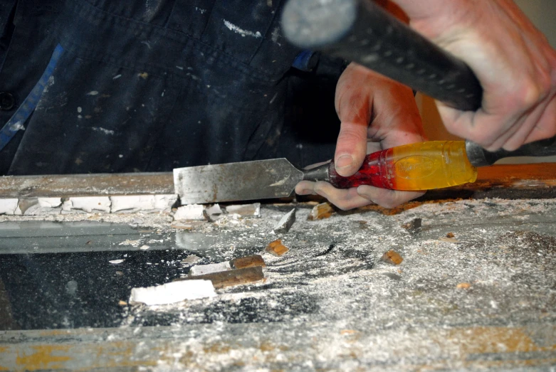 an person is carving wooden with a sharp knife