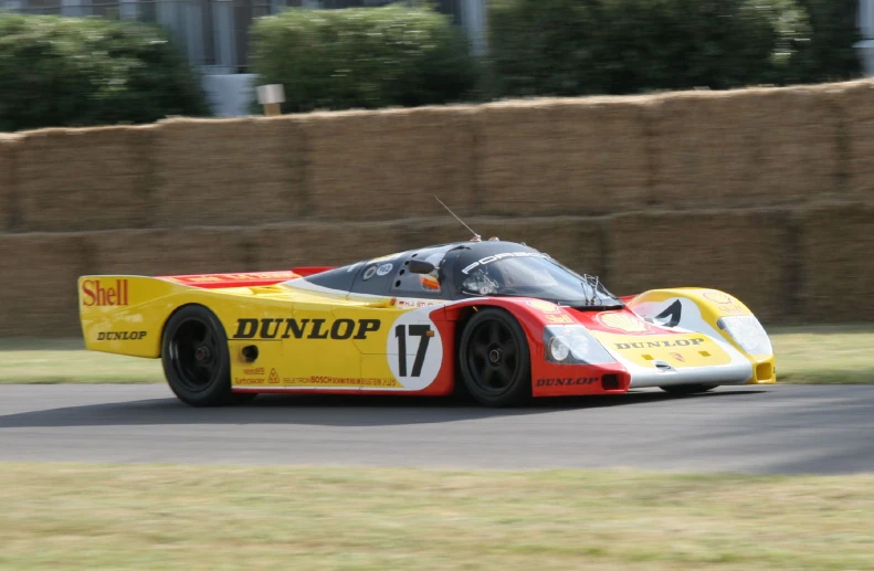 the yellow and red race car is racing on the road