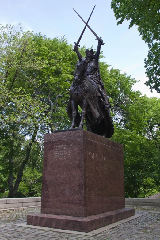 a statue of a man on horseback holding swords