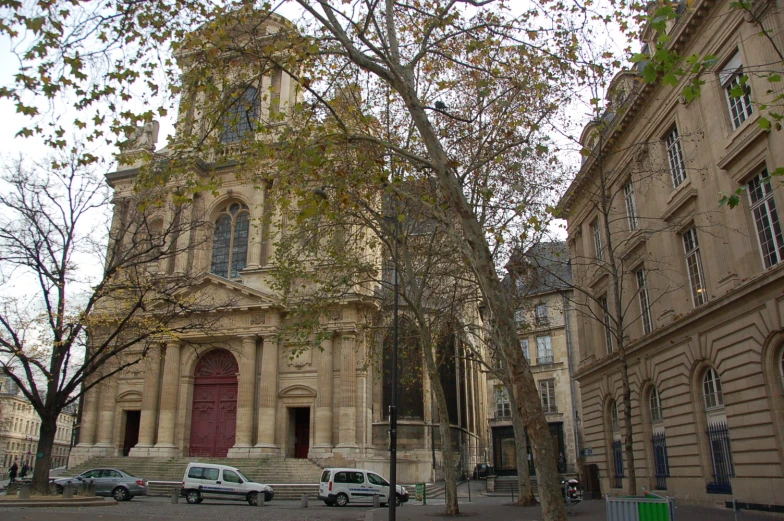 a group of cars sit parked in front of two buildings