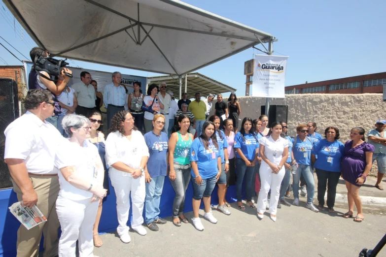 people in blue shirts and white shorts are gathered at an event