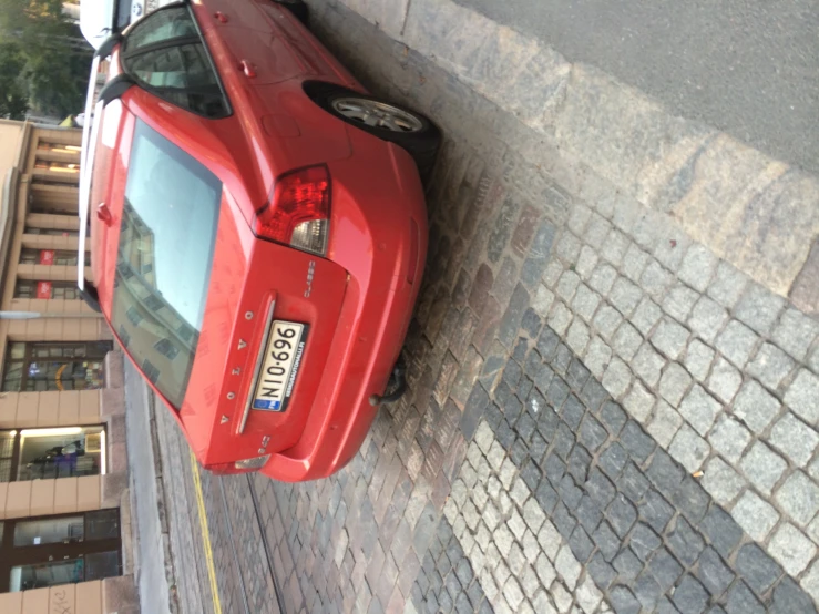 a red car is parked on the street