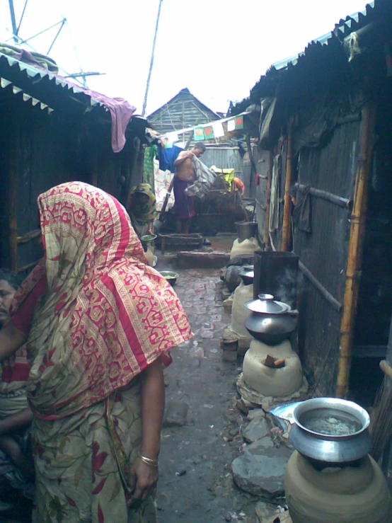 a woman in a brightly colored scarf in a poor village