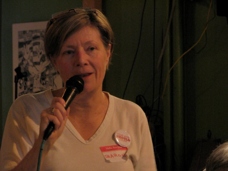 the older woman is holding a microphone and speaking