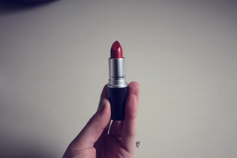a woman is holding her lipstick with an eyeliner