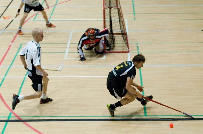 men in the gym playing a game of field hockey