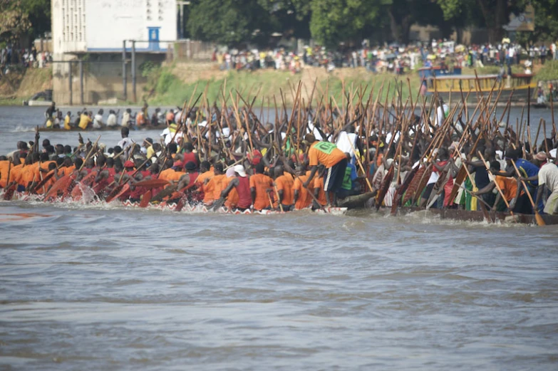 many people in orange are walking on a long boat