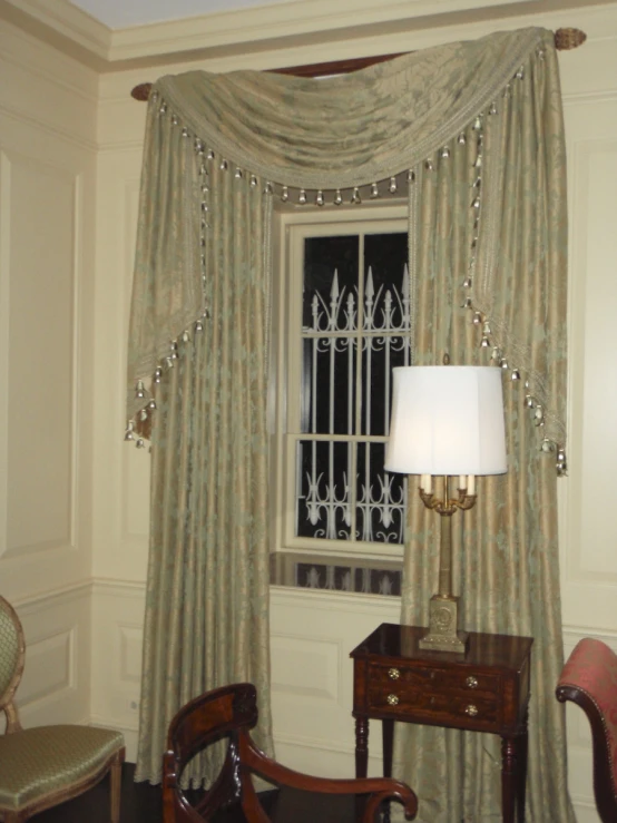 two chairs, lamp and window covered in curtains