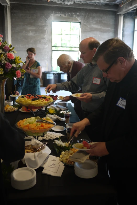 a group of men preparing different food for people