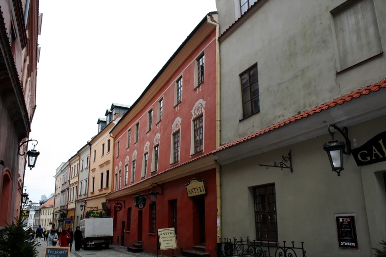 a street with a group of buildings on each side and signs attached to them