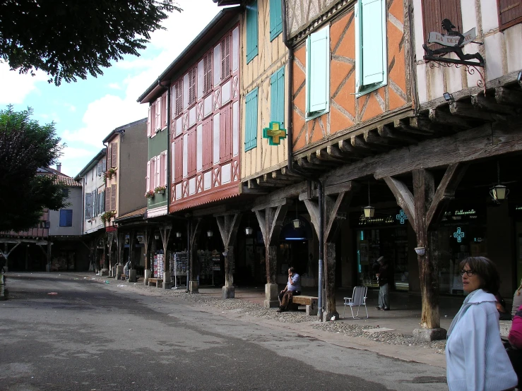 a row of multi - colored buildings stand along the empty street