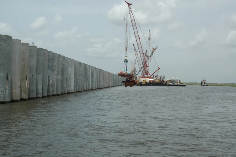 large crane sitting on top of water by a cement wall