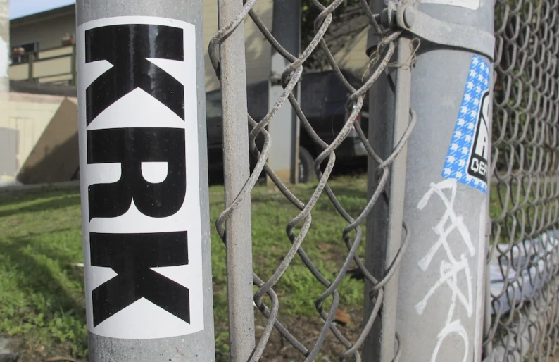 a metal chain link fence with a sticker that reads, rock