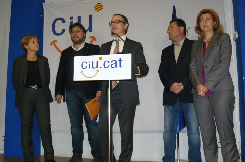 five business people standing on stage with sign for ciu cat