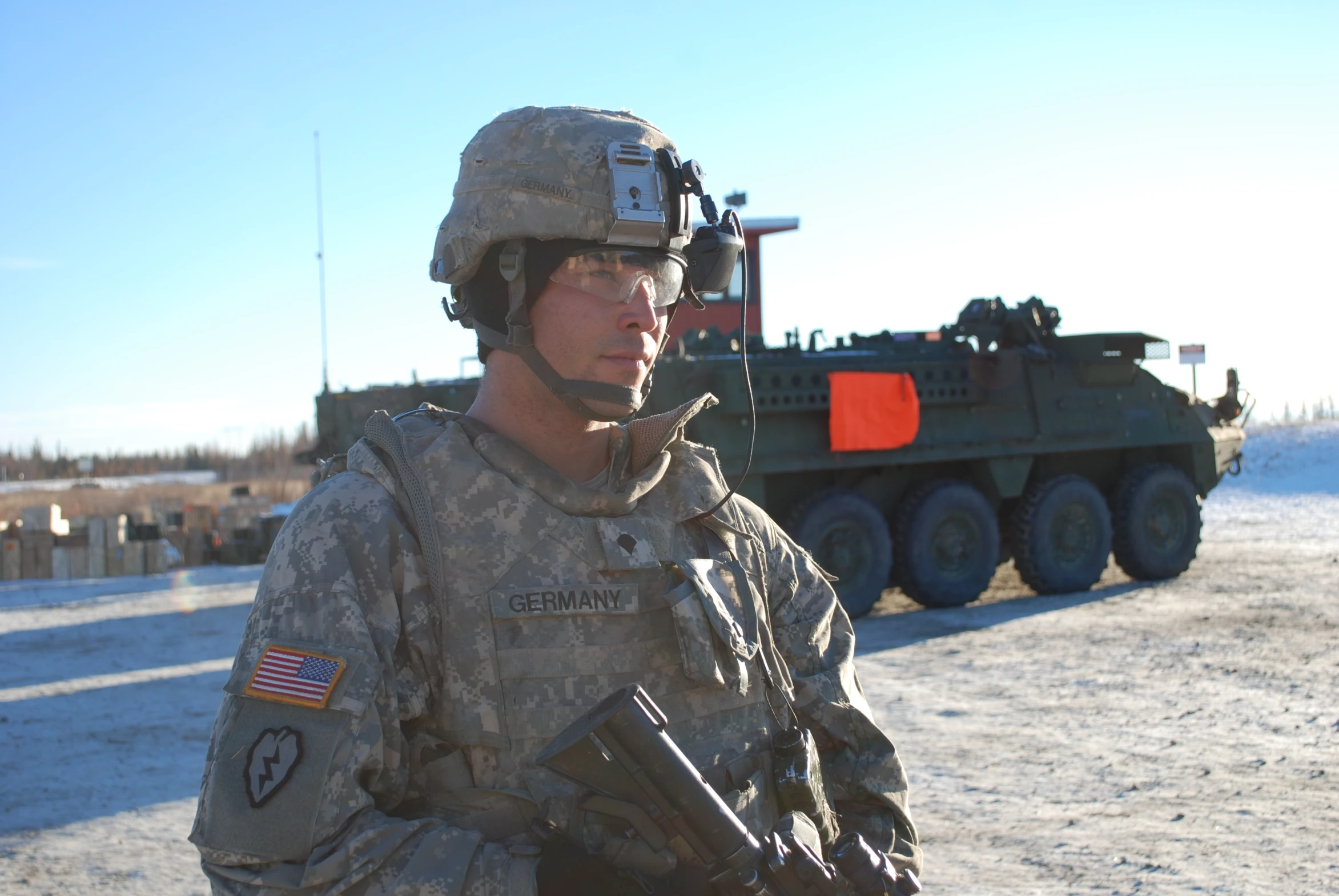 a soldier standing next to a large machine in the snow