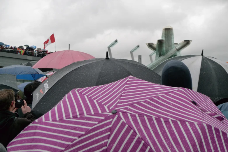 a group of people are holding umbrellas in front of a monument