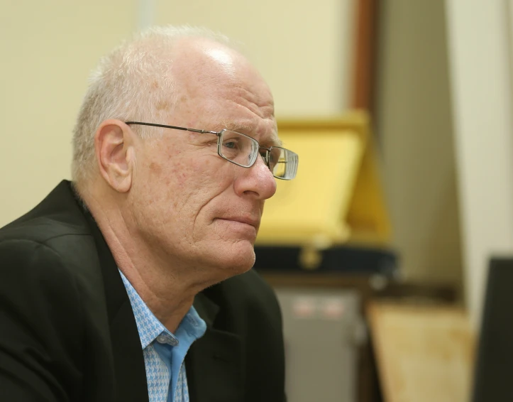 an older man sitting at a computer desk