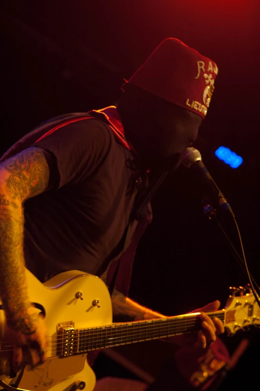 the guitarist is playing his guitar in front of the microphone