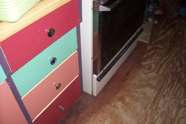 a black oven on a painted dresser next to a door