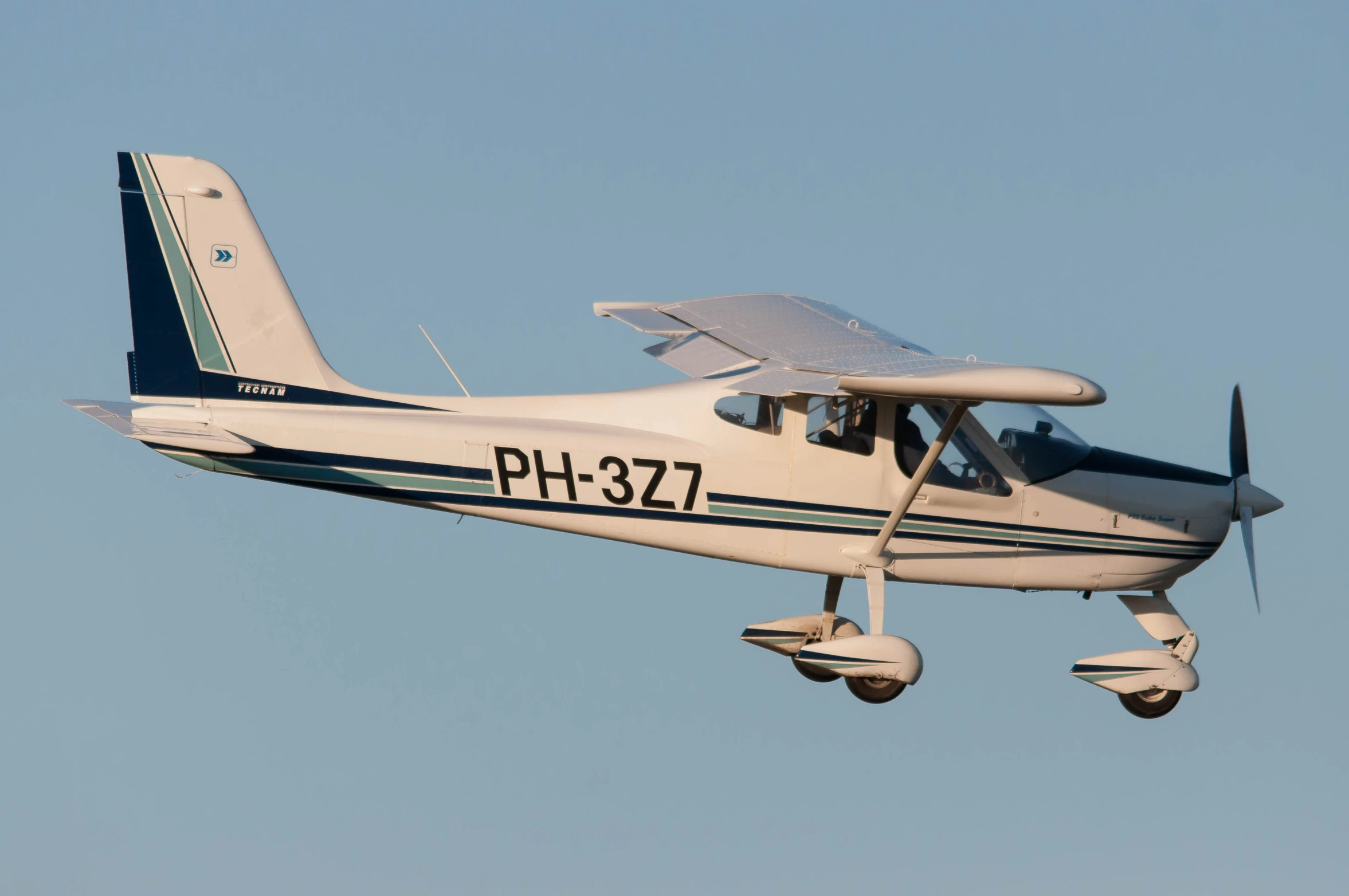 a plane flies high in the sky, on a clear day