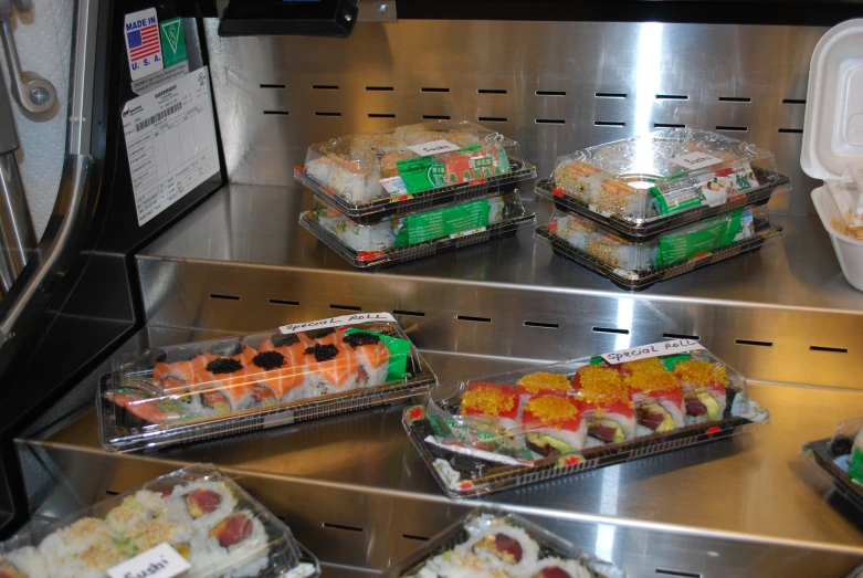 several different food containers with sushi in them