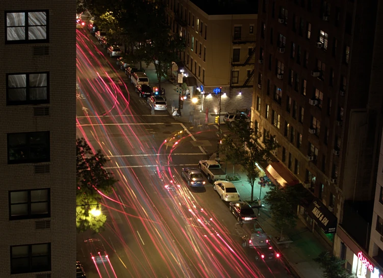 a busy city street with cars driving on the road at night