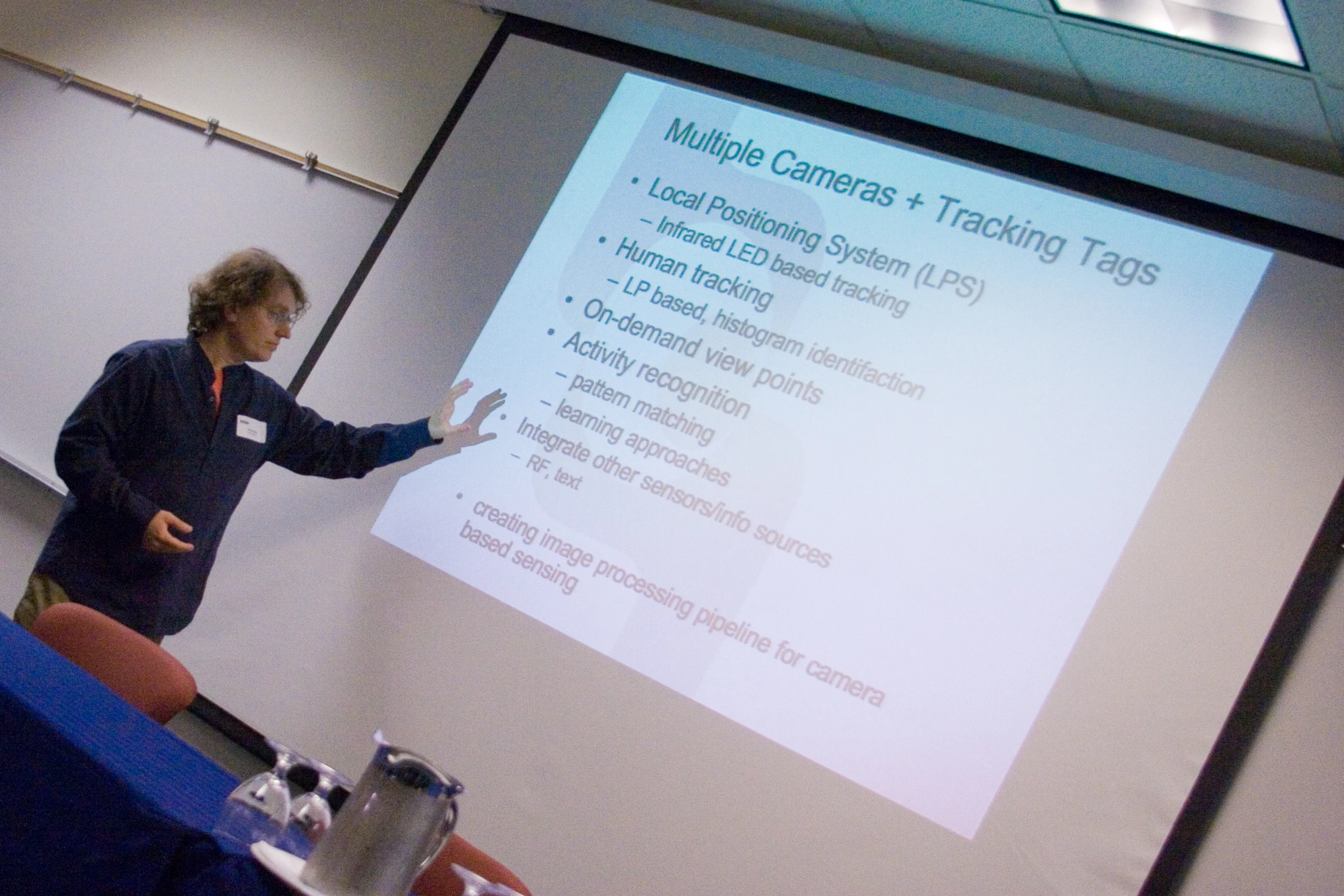 there is a woman standing near a whiteboard in a room